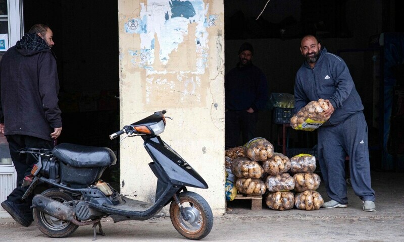 A man picks up potatoes at a store selling vegetable in the village of Kfar Kila near the border with Israel, on December 21, 2023.&mdash;AFP
