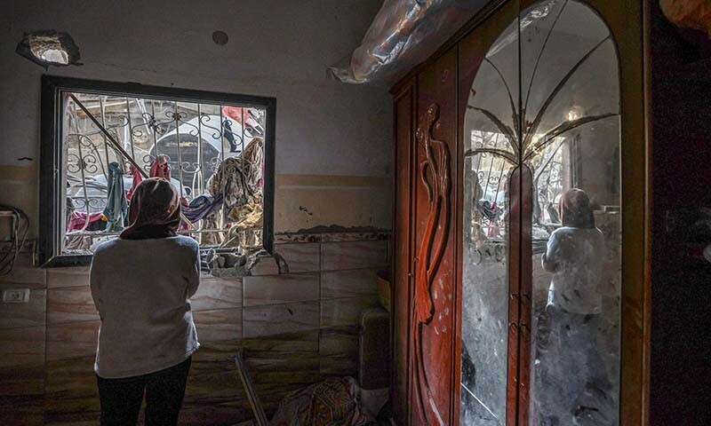 A Palestinian woman checks the damage inside a house following Israeli bombardment in Rafah, in the southern Gaza Strip on December 22, 2023. &mdash; AFP