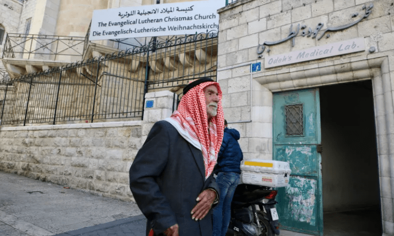 A Palestinian man stands in front of The Evangelical Lutheran Christmas Church in Bethlehem, occupied West Bank. &mdash; Al Jazeera