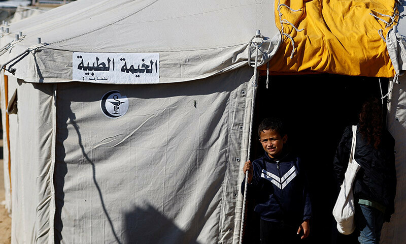 A displaced Palestinian boy stands in the entry of the medical tent, set up by volunteers in Rafah in the southern Gaza Strip, December 24, 2023. &mdash; Reuters