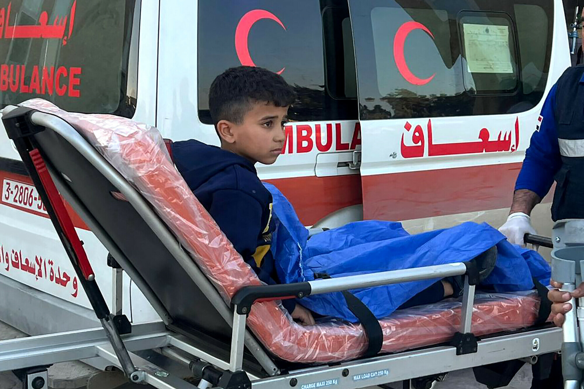 A wounded Palestinian child is wheeled into an ambulance at the Rafah border crossing in Egypt after being evacuated from the Gaza Strip, on December 25. &mdash; AFP