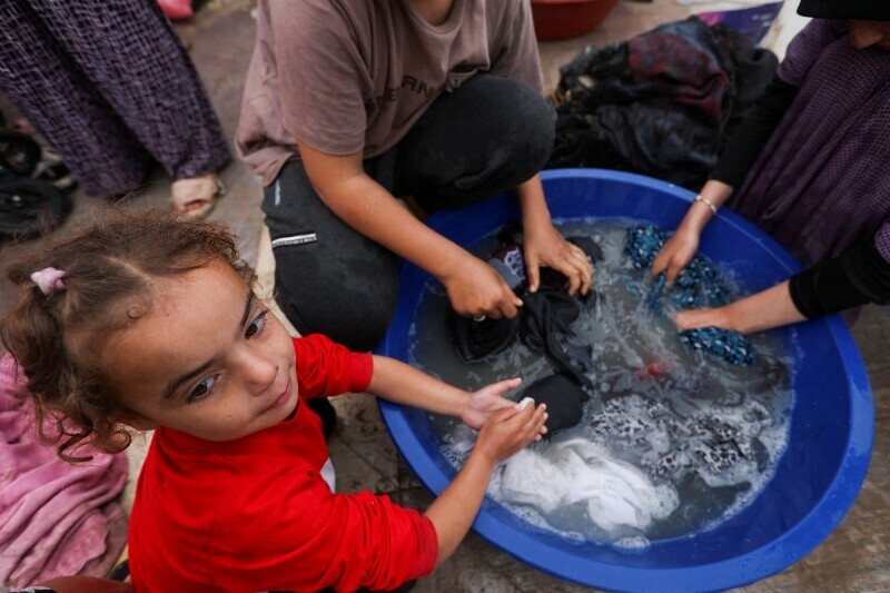 A child looks on as displaced Palestinians, who fled their houses due to Israeli strikes, shelter in a tent camp in Rafah in the southern Gaza Strip, December 25. &mdash; Reuters