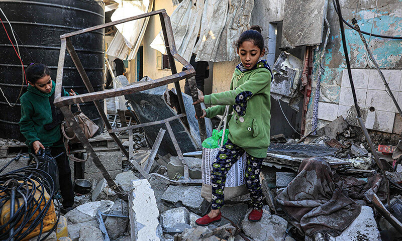 Palestinian girls search the rubble of a building following Israeli bombardment in Rafah in the southern Gaza Strip on December 26, 2023. &mdash; AFP