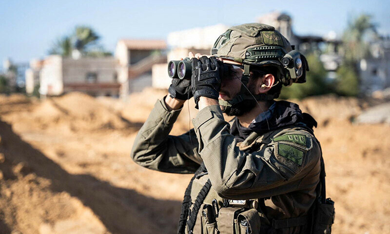 An Israeli soldier looks through binoculars in the Gaza Strip on December 27, 2023. &mdash; Reuters