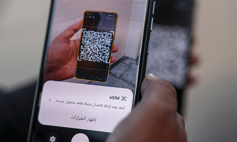 Palestinian journalists try to connect their mobile to read e-SIM cards in Rafah on the southern Gaza Strip on December 27, 2023. &mdash; AFP