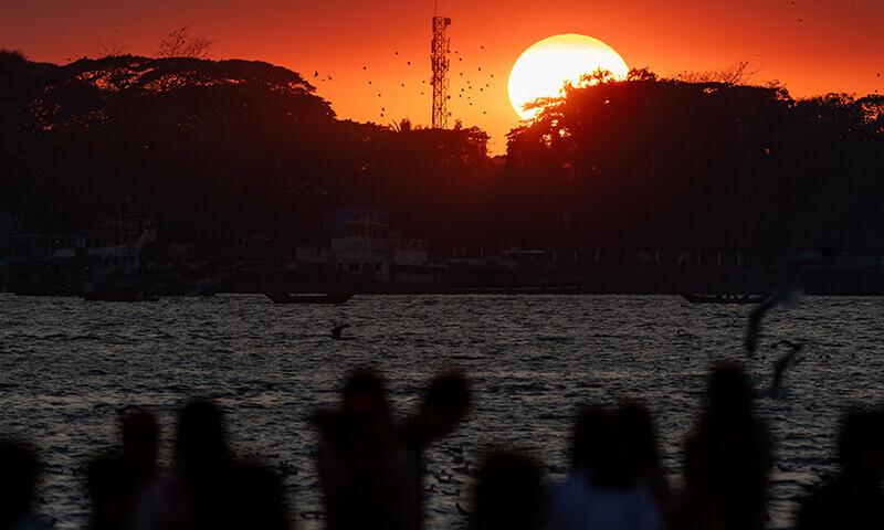 People gather to observe the last sunset of the year at the Botahtaung jetty on Yangon River in Yangon, Myanmar on Dec 31. — AFP