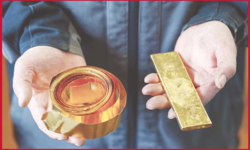 An employee shows gold on a roll and in the form of a bar at the gold-beating company Noris Blattgold in Schwabach, southern Germany. In the Bavarian city of Schwabach, the production of gold leaf to decorate homes, churches, statues or picture frames has been a widespread craft for many centuries, a unique feature in Germany. But while in the 19th century, hundreds of people in the town were familiar with the art of “stamping” gold leaf, today only two companies remain that can perpetuate these methods — while adapting to modern times.—AFP An employee shows gold on a roll and in the form of a bar at the gold-beating company Noris Blattgold in Schwabach, southern Germany. In the Bavarian city of Schwabach, the production of gold leaf to decorate homes, churches, statues or picture frames has been a widespread craft for many centuries, a unique feature in Germany. But while in the 19th century, hundreds of people in the town were familiar with the art of “stamping” gold leaf, today only two companies remain that can perpetuate these methods — while adapting to modern times.—AFP