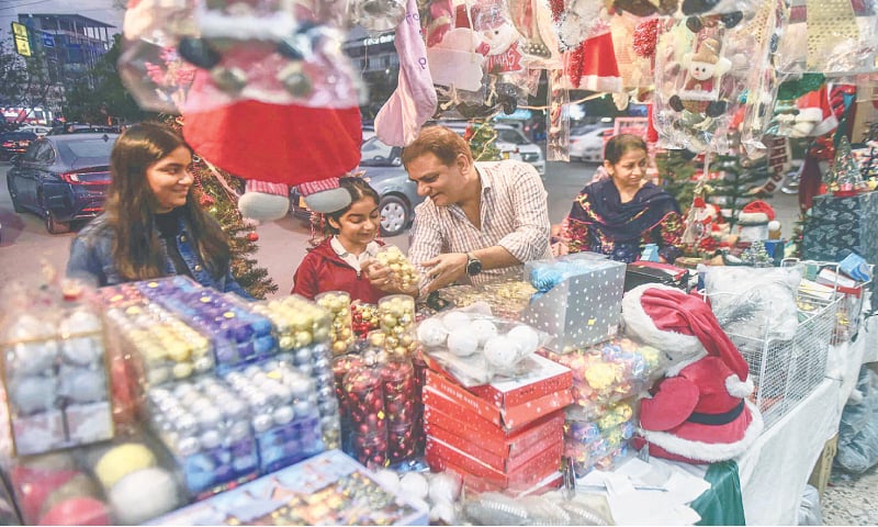 A family selects Christmas decorations at a stall in Clifton.&mdash;Fahim Siddiqi / White Star