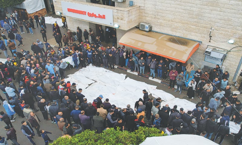 Mourners gather beside the bodies of Palestinians killed in an Israeli strike on Christmas morning, at a hospital in the central Gaza Strip, on Monday.&mdash;Reuters