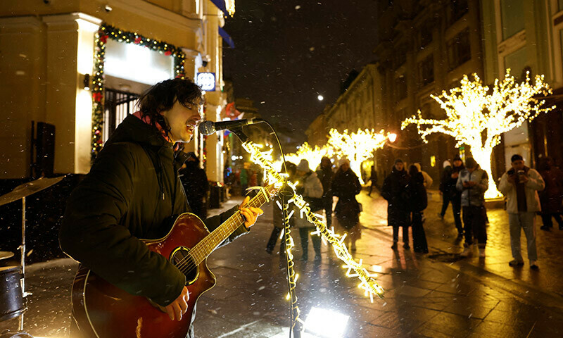 A musician plays the guitar and sings on a street during the New Year’s Eve celebrations in Moscow, Russia December 31, 2023. — AFP