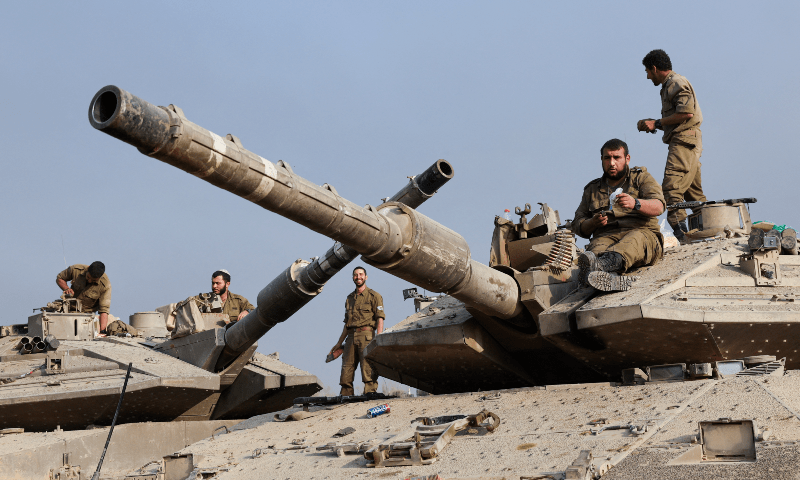  Israeli soldiers work on their tanks, near the Israel-Gaza border, in southern Israel on Jan 1, 2024. &mdash; Reuters 