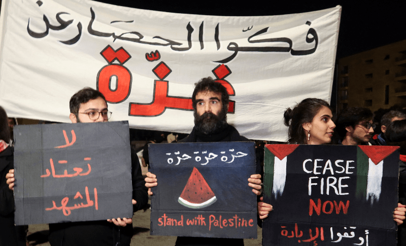 Demonstrators hold signs during a protest demanding a permanent ceasefire in Gaza, on New Year&rsquo;s Eve in Beirut, Lebanon on Dec 31, 2023. &mdash; Reuters 