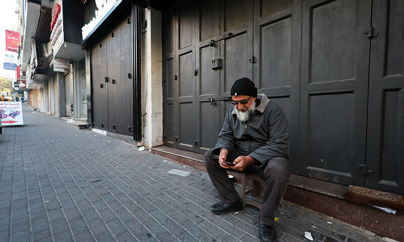A Palestinian man sits in front of a closed shop during a strike as a protest against the killing of senior Hamas official, Saleh al-Arouri, in Hebron in the Israeli-occupied West Bank January 3, 2024. &mdash; Reuters
