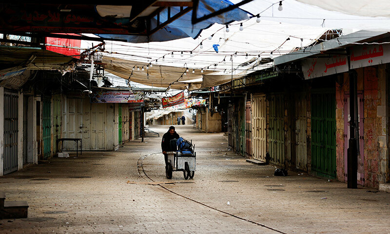 A Palestinian man walks past closed shops during a strike as a protest against the killing of senior Hamas official, Saleh al-Arouri, in Hebron in the Israeli-occupied West Bank January 3, 2024. &mdash; Reuters