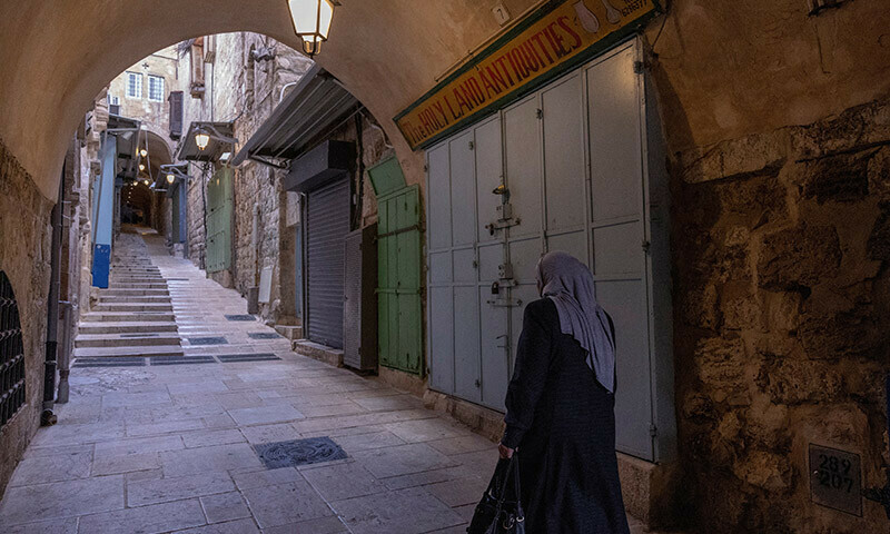 A woman walks past closed shops during a strike as a protest against the killing of senior Hamas official, Saleh al-Arouri, in Jerusalem&rsquo;s Old City. &mdash; Reuters