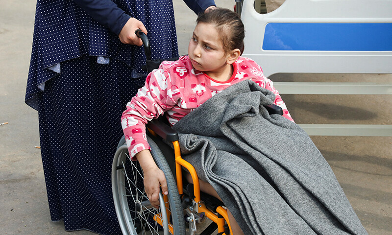 Palestinian girl Noor Marouf, whose limb was amputated after being wounded in an Israeli strike, sits in a wheelchair as she is helped by her aunt at the European Hospital, in Rafah in the southern Gaza Strip on December 28, 2023 &mdash; Reuters
