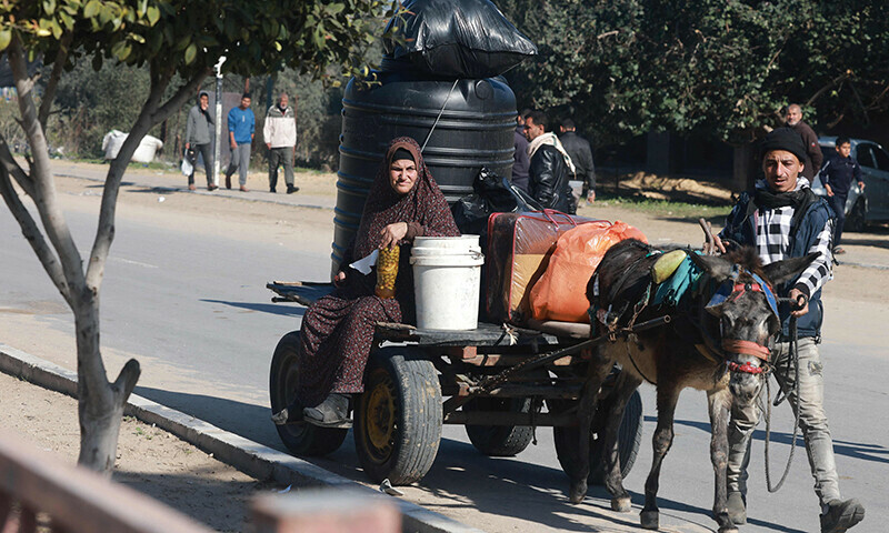 People carrying some of their belongings arrive in Rafah on the southern Gaza Strip on January 4. &mdash; AFP