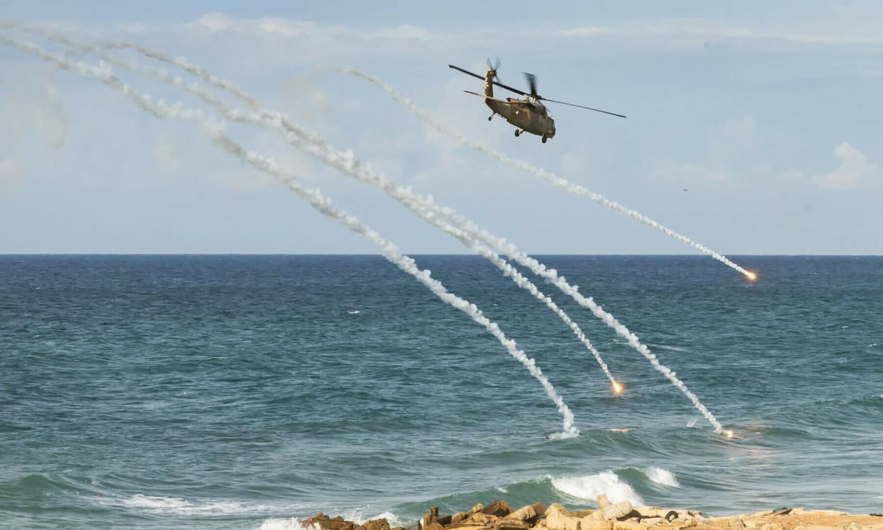  An Israeli helicopter fires flares as it flies over a beach on the Gaza Strip on Jan 4, 2024. &mdash; Israeli army via AFP 
