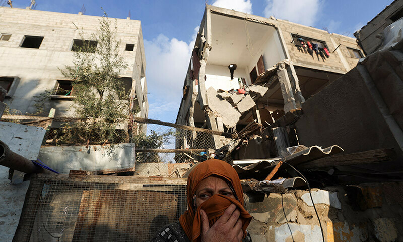 A Palestinian woman stands in front of a house damaged in an Israeli strike in Rafah, in the southern Gaza Strip, January 5, 2024. &mdash; Reuters
