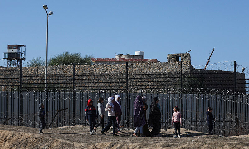 Displaced Palestinians, who fled their houses due to Israeli strikes, walk as they seek shelter at the border with Egypt, in Rafah in the southern Gaza Strip, January 7, 2024. &mdash; Reuters