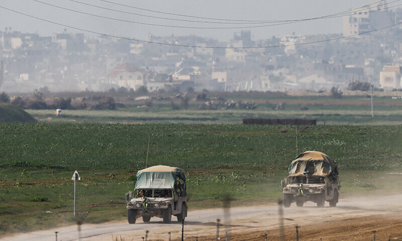 Israeli military vehicles drive near the Israel-Gaza border as seen from southern Israel, January 8, 2024. &mdash; Reuters