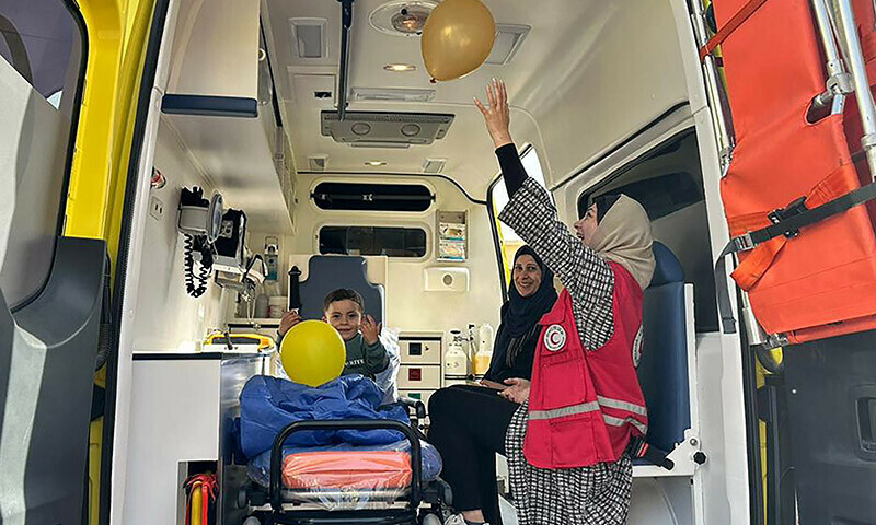 Egyptian Red Crescent volunteers play with balloons with a Palestinian child in an ambulance, after he was evacuated from Gaza through the Rafah border crossing with Egypt on January 9, 2024. &mdash; AFP