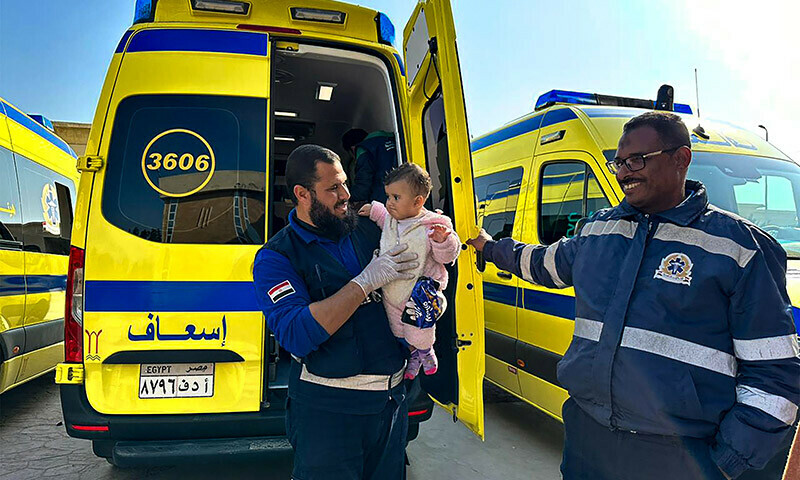 An Egyptian paramedic holds a Palestinian child evacuated from Gaza through the Rafah border crossing with Egypt on January 9, 2024. &mdash; AFP