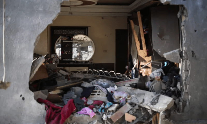 Debris lies in a damaged room, as a Palestinian man is reflected in a mirror, at the site of an Israeli strike, in Rafah in the southern Gaza Strip on January 10. &mdash; Reuters