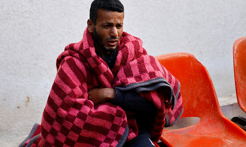 A mourner reacts as he sits near the site where the bodies of Palestinians killed in an Israeli strike are kept&mdash; Reuters