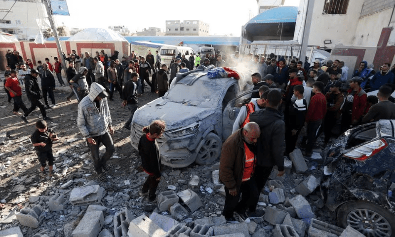 Palestinians gather next to a damaged vehicle as they inspect the site of an Israeli strike in Deir Al-Balah in the central Gaza Strip on January 10, 2024. &mdash; Reuters