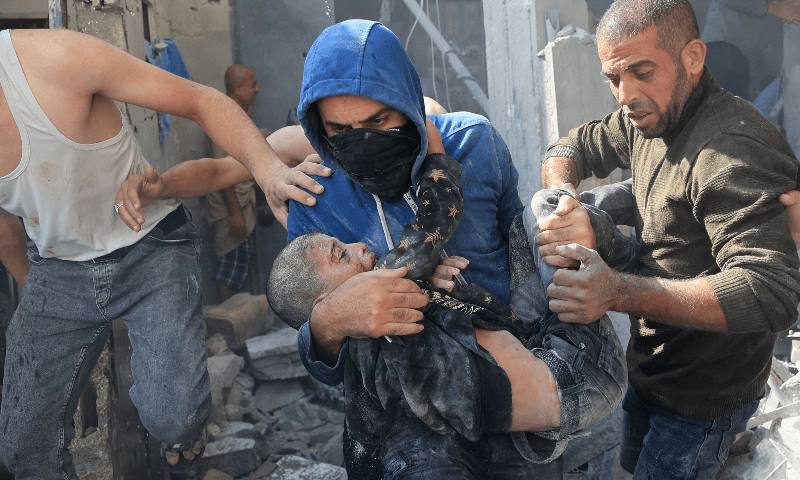  A Palestinian man carries a victim of an Israeli bombardment in Rafah in the southern Gaza Strip on Nov 7, 2023. &mdash; AFP/File 