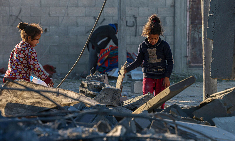 Children check the rubble following Israeli bombardment in Rafah in the southern Gaza Strip on January 13. &mdash; AFP