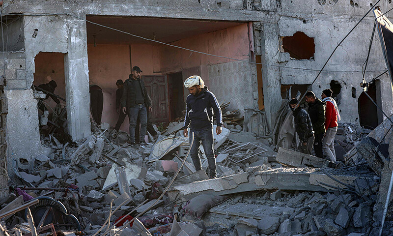 People inspect the damage following Israeli bombardment in Rafah in the southern Gaza Strip on January 13. &mdash; AFP