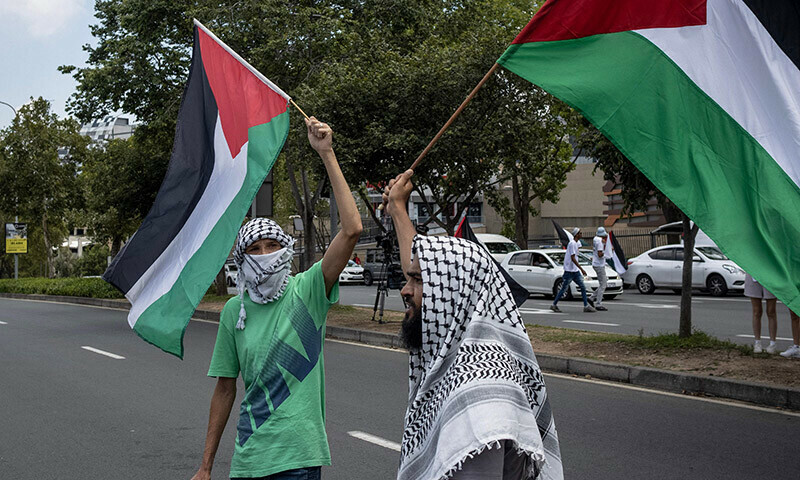 Pro-Palestinian protesters hold Palestinian flags as they gather in front of the US Consulate in Sandton, Johannesburg, on January 13. &mdash; AFP