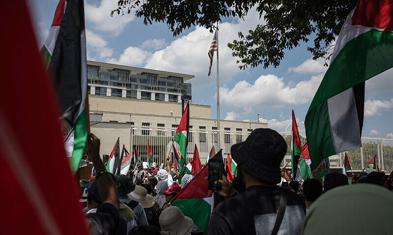 Pro-Palestinian protesters hold placards and Palestinian flags as they gather in front of the US Consulate in Sandton, Johannesburg, on January 13. &mdash; AFP