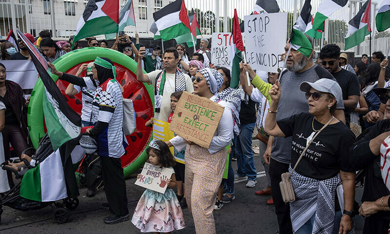 Pro-Palestinian protesters hold placards and Palestinian flags as they gather in front of the US Consulate in Sandton, Johannesburg, on January 13. &mdash; AFP