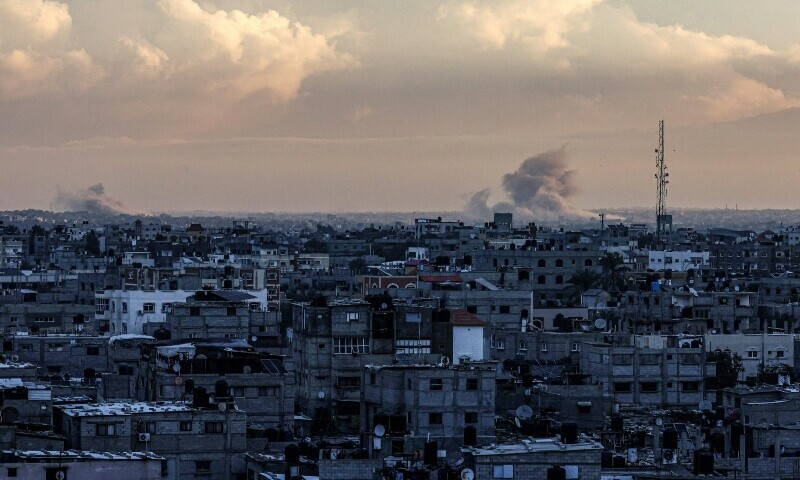 A picture taken from Rafah shows smoke billowing over Khan Younis in the southern Gaza Strip during an early morning Israeli bombardment, as the conflict between Israel and the Palestinian fighter group Hamas enters its 100th day on January 14, 2024.&mdash;AFP
