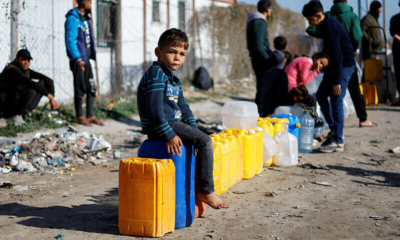 A displaced Palestinian boy, who fled his house due to Israeli strikes, sits on a water canister at a tent camp in Rafah in the southern Gaza Strip on January 18. &mdash; Reuters