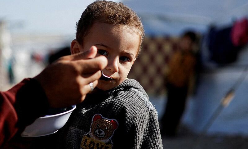 A displaced Palestinian child is fed at a tent camp in Rafah in the southern Gaza Strip on January 18. &mdash; Reuters