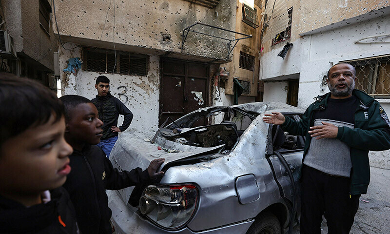 Palestinians gather around a damaged car in a refugee camp in Tulkarem, where the Israeli army carried out overnight raids, on January 19, 2024 in the occupied West Bank. &mdash; AFP