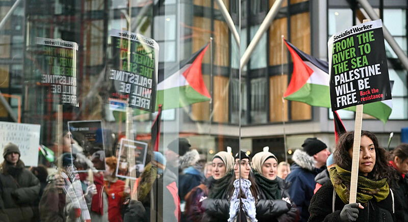 Pro-Palestinian supporters hold placards and chant slogans as they reflected on a window during a &ldquo;Day of Action for Palestine&rdquo; demonstration outside the British multinational arms, security and aerospace company BAE Systems, in London, on January 20. &mdash; AFP