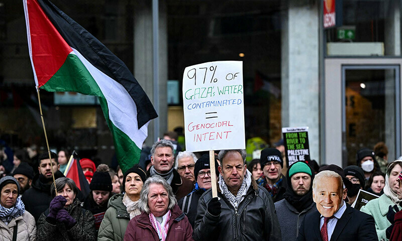 Pro-Palestinian supporters including one wearing a mask depicting US President Joe Biden (R), hold placards and chant slogans as they take part in a &ldquo;Day of Action for Palestine&rdquo; demonstration outside the British multinational arms, security and aerospace company BAE Systems, in London, on January 20. &mdash; AFP
