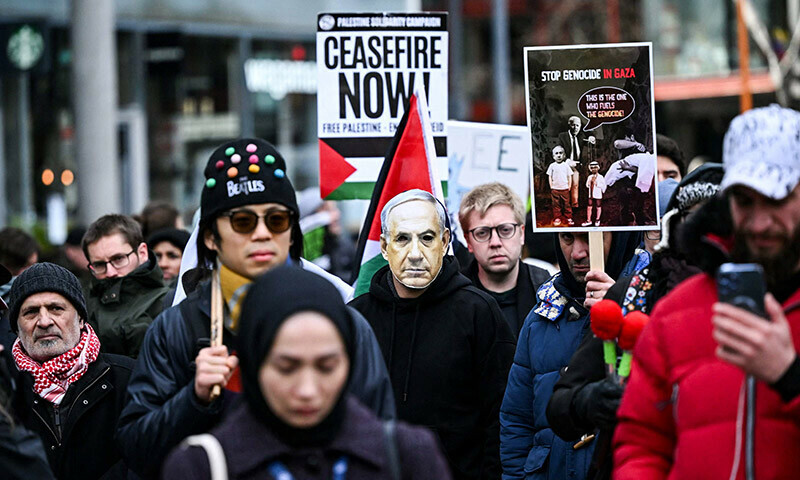 Pro-Palestinian supporters including one wearing a mask depicting Israel&rsquo;s Prime Minister Benjamin Netanyahou (C), hold placards and chant slogans as they take part in a &ldquo;Day of Action for Palestine&rdquo; demonstration outside the British multinational arms, security and aerospace company BAE Systems, in London, on January 20. &mdash; AFP