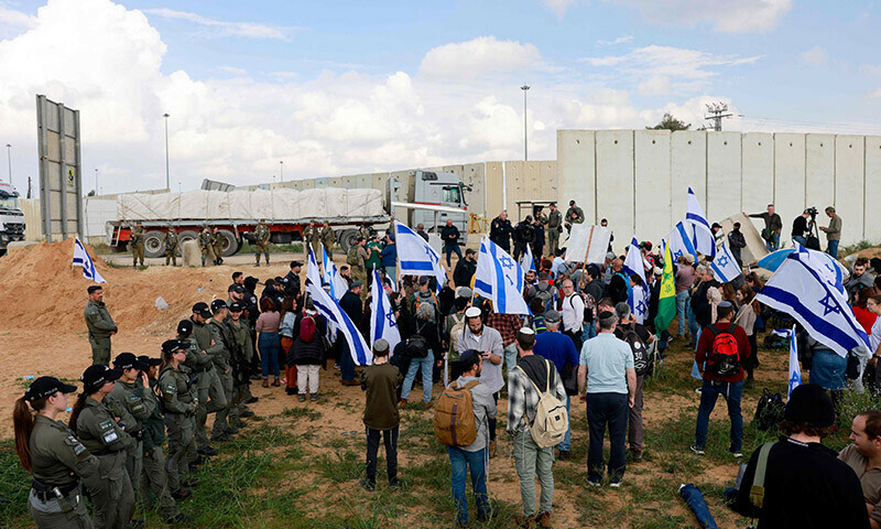 Israeli border police stand guard as protesters, including relatives of the hostages held in Gaza since the October 7 attacks by Hamas, take part on a demonstration aimed at blocking aid trucks from entering the Palestinian territory, on the Israeli side of the Kerem Shalom border crossing with the southern Gaza Strip on January 29. &mdash; AFP