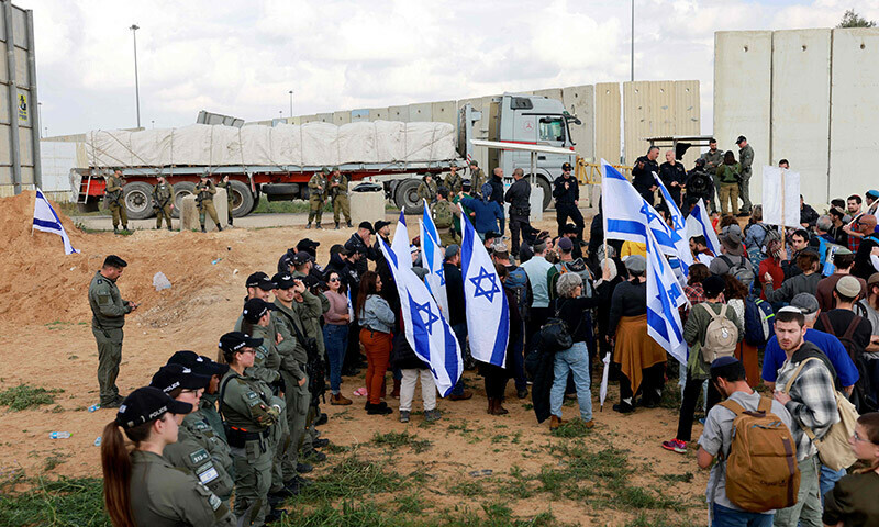 Israeli border police stand guard as protesters, including relatives of the hostages held in Gaza since the October 7 attacks by Hamas, take part on a demonstration aimed at blocking aid trucks from entering the Palestinian territory, on the Israeli side of the Kerem Shalom border crossing with the southern Gaza Strip on January 29. &mdash; AFP
