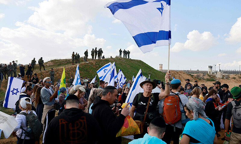 Israeli protesters, including relatives of the hostages held in Gaza since the October 7 attacks by Hamas, wave national flags during a demonstration aimed at blocking aid trucks from entering the Palestinian territory, on the Israeli side of the Kerem Shalom border crossing with the southern Gaza Strip on January 29. &mdash; AFP
