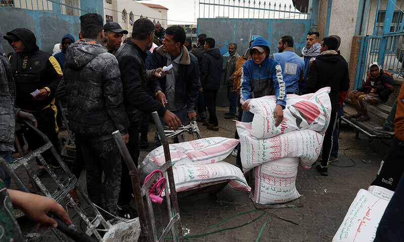 Palestinians gather to receive bags of flour distributed by the United Nations Relief and Works Agency (UNRWA) in Rafah in the southern Gaza Strip on January 29. &mdash; Reuters