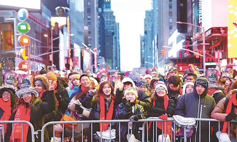 NEW YORK: Revellers get ready to celebrate the New Year&rsquo;s Eve Ball drop in Times Square, on Monday.&mdash;AFP