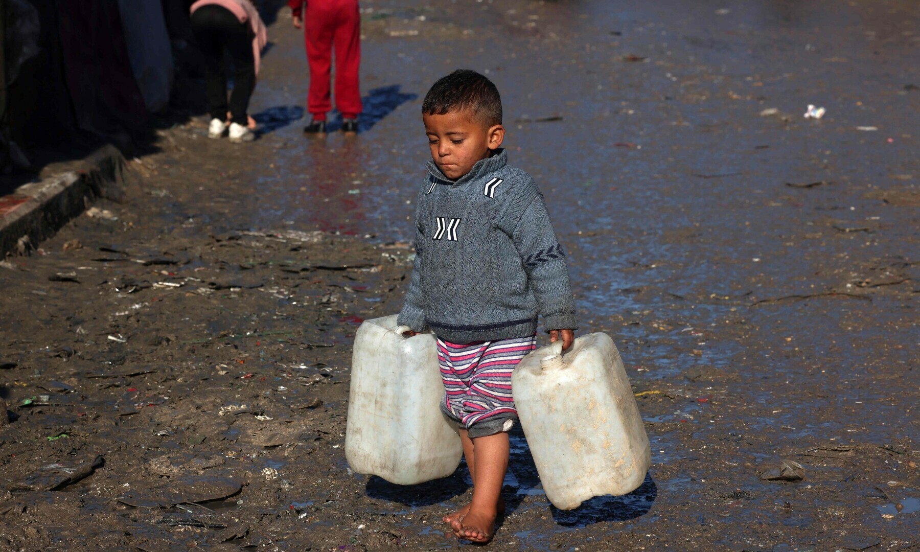  A young boy carries empty jerricans in Rafah in the southern Gaza Strip on Feb 3, 2024. &mdash; AFP 