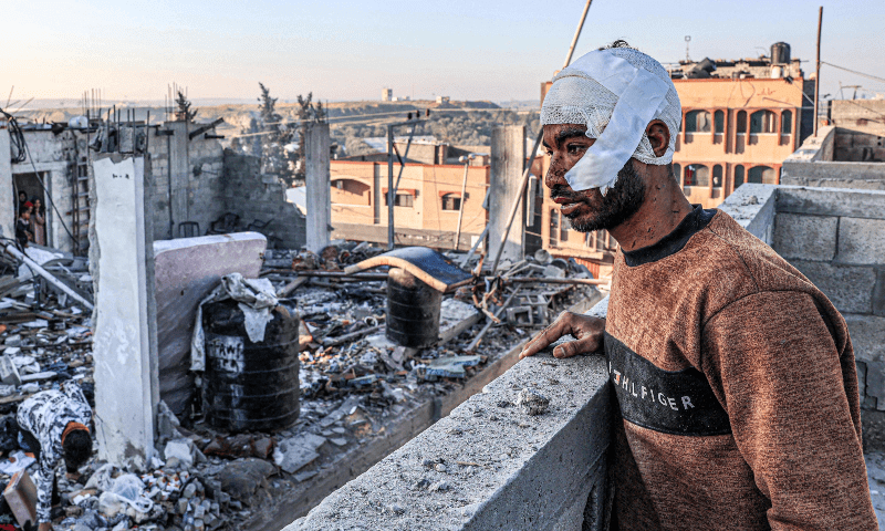 An injured man with a bandaged head looks on while standing next to the rubble and debris of a destroyed building in the aftermath of Israeli bombardment on Rafah in the southern Gaza Strip on Feb 7, 2024. - AFP
